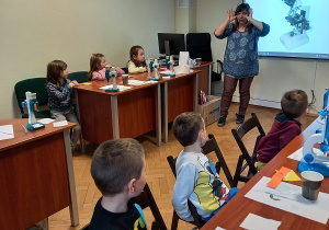 Dzieci uważnie słuchają mini wykładu na temat mikroskopów